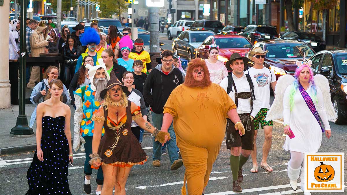 a group of people walking down the street wearing different Halloween attire